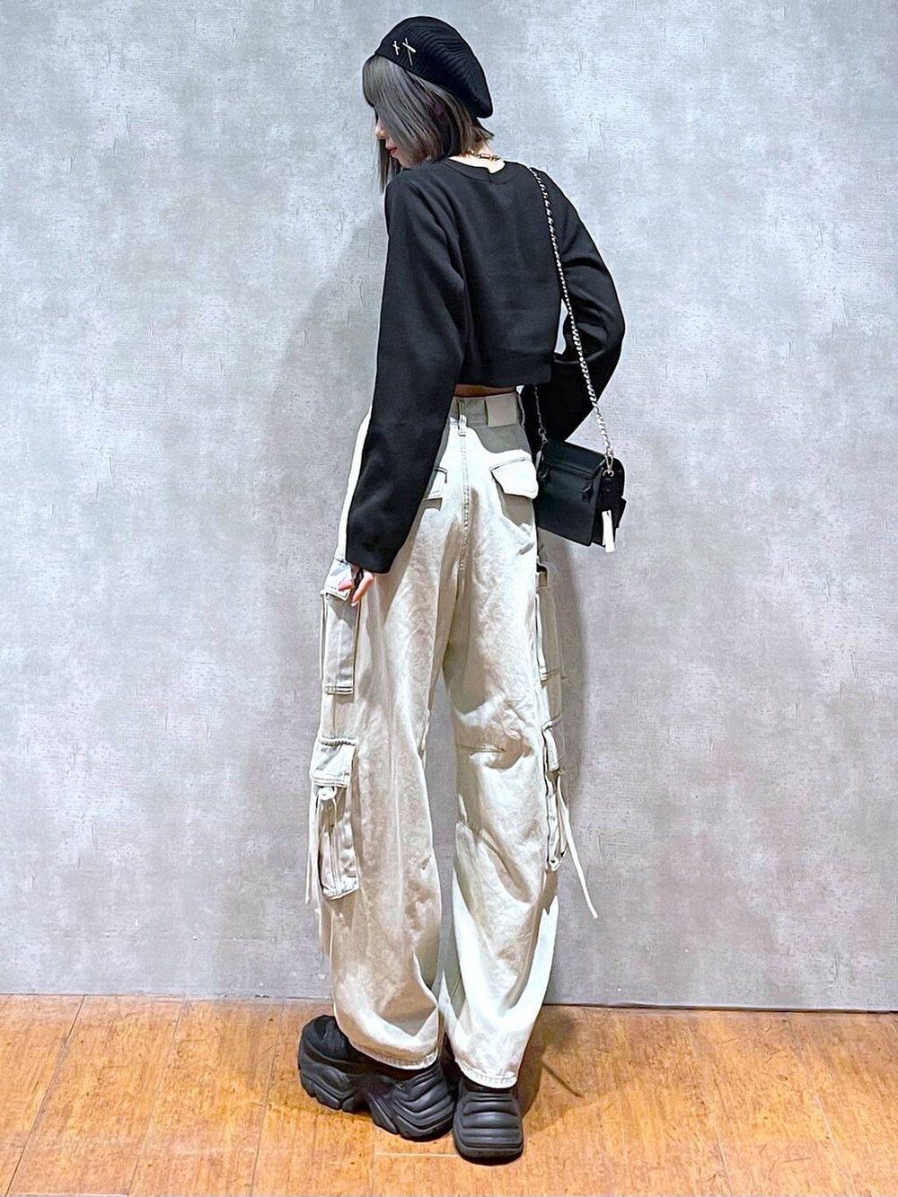 ブラック系のスニーカー、ブルー系のデニムパンツ、ブラック系のショルダーバッグを着用したレディースの秋コーディネートの4枚目の写真