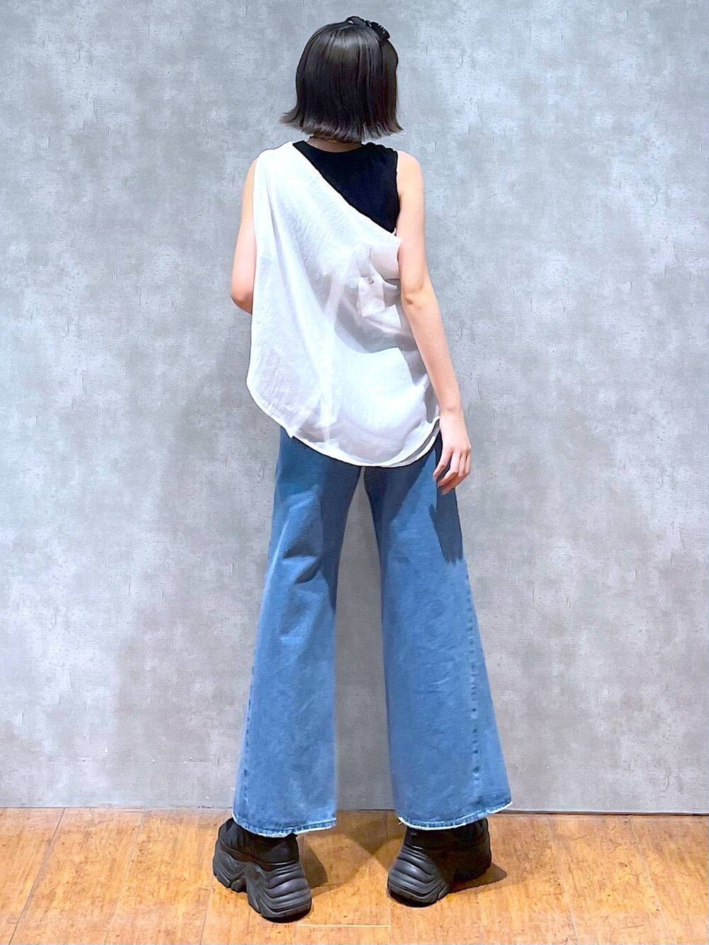 ブラック系のスニーカー、ブラック系のタンクトップ、ブルー系のデニムパンツを着用したレディースの夏コーディネートの5枚目の写真