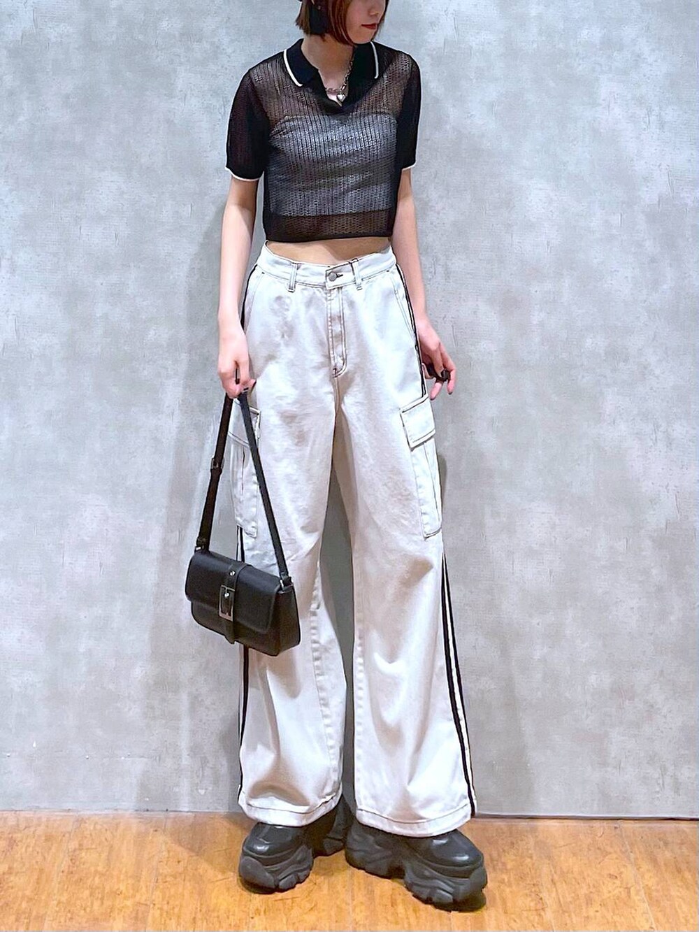 ブラック系のスニーカー、ホワイト系のデニムパンツ、ホワイト系のキャミソールを着用したレディースの夏コーディネートの4枚目の写真