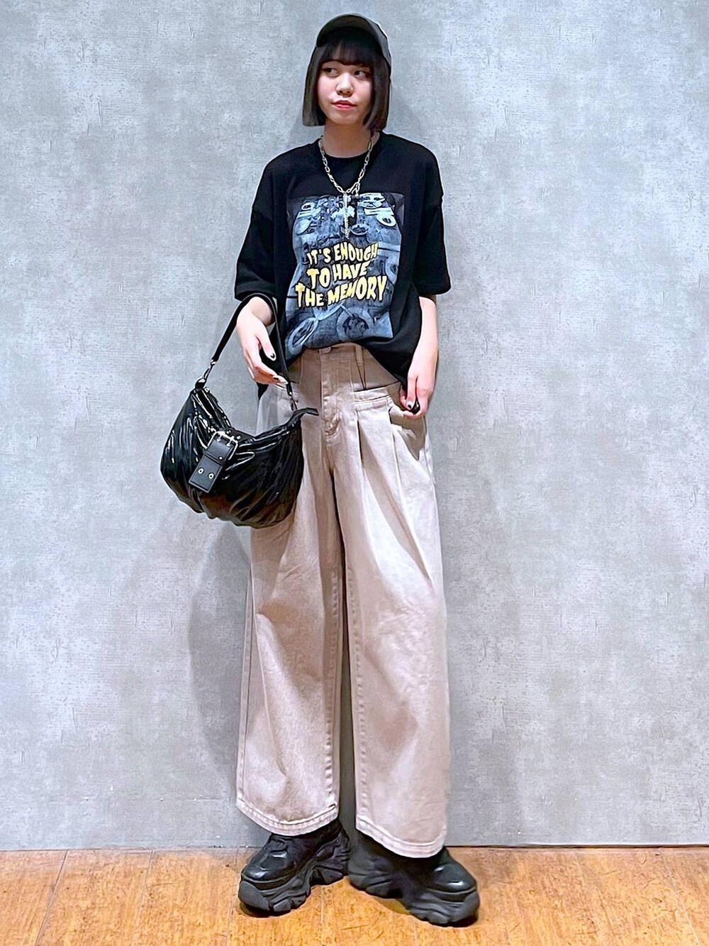 ブラック系のスニーカー、ブラック系のショルダーバッグ、ベージュ系のデニムパンツを着用したレディースの夏コーディネートの7枚目の写真