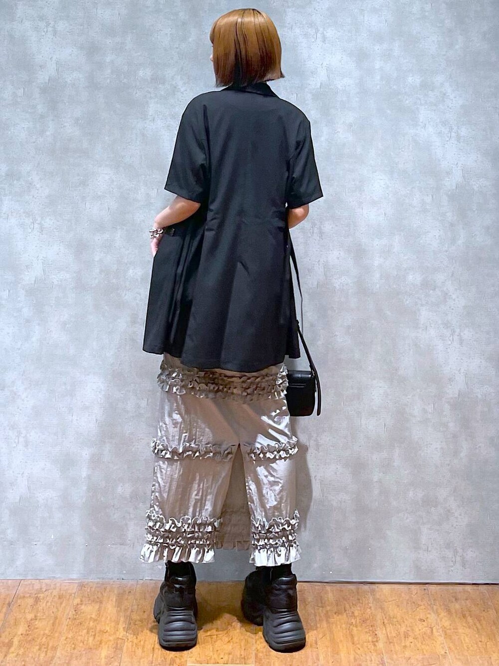 ブラック系のスニーカー、ブラック系のハンドバッグ、ホワイト系のTシャツ/カットソーを着用したレディースの夏コーディネートの5枚目の写真