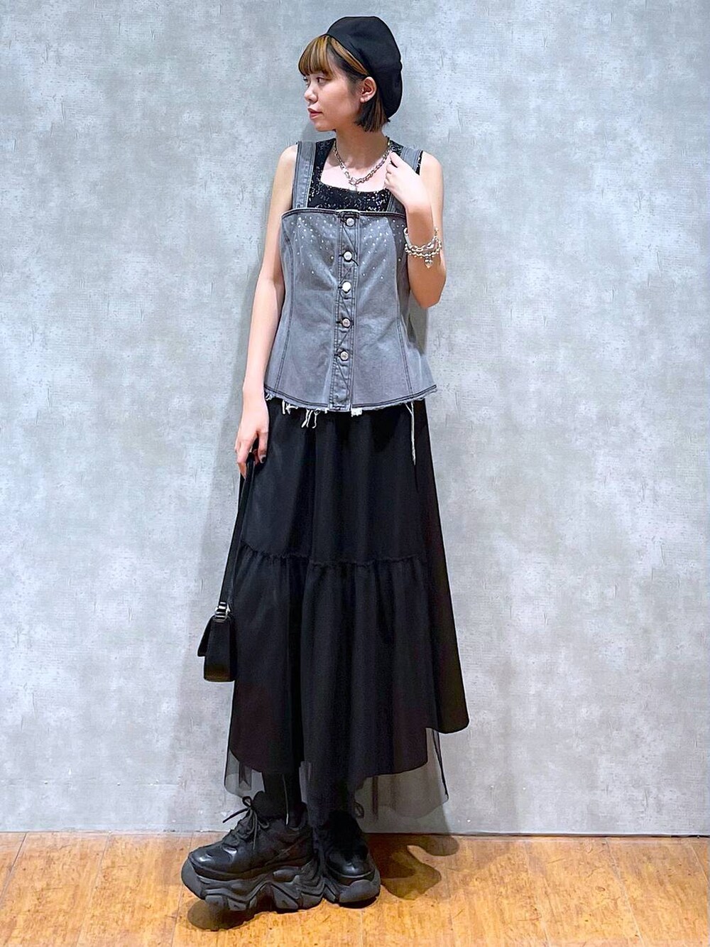 ブラック系のスニーカー、ブラック系のハンドバッグ、ブラック系のスカートを着用したレディースの夏コーディネートの3枚目の写真