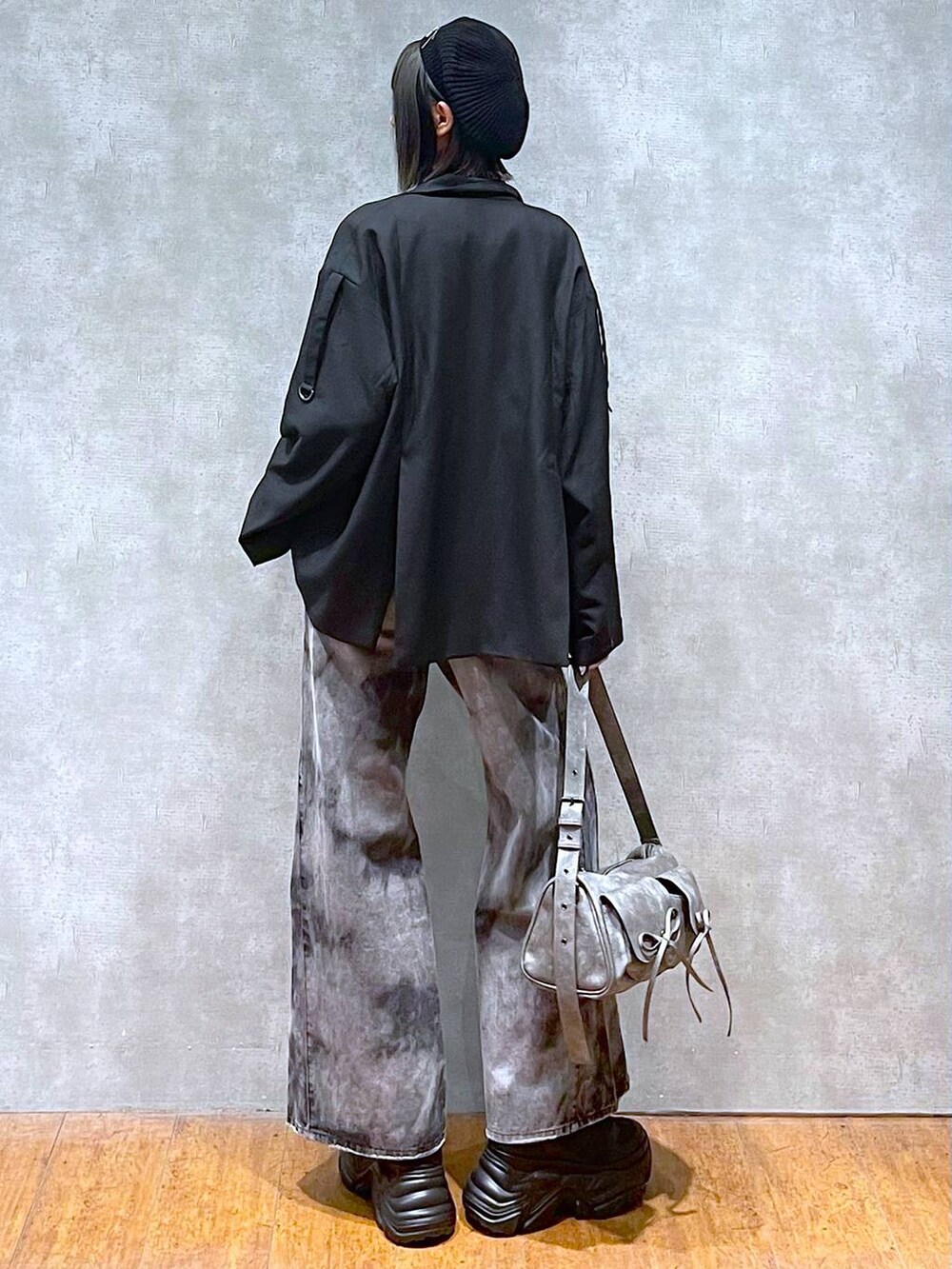 ブラック系のスニーカー、グレー系のショルダーバッグ、ブラック系のデニムパンツを着用したレディースの秋コーディネートの6枚目の写真