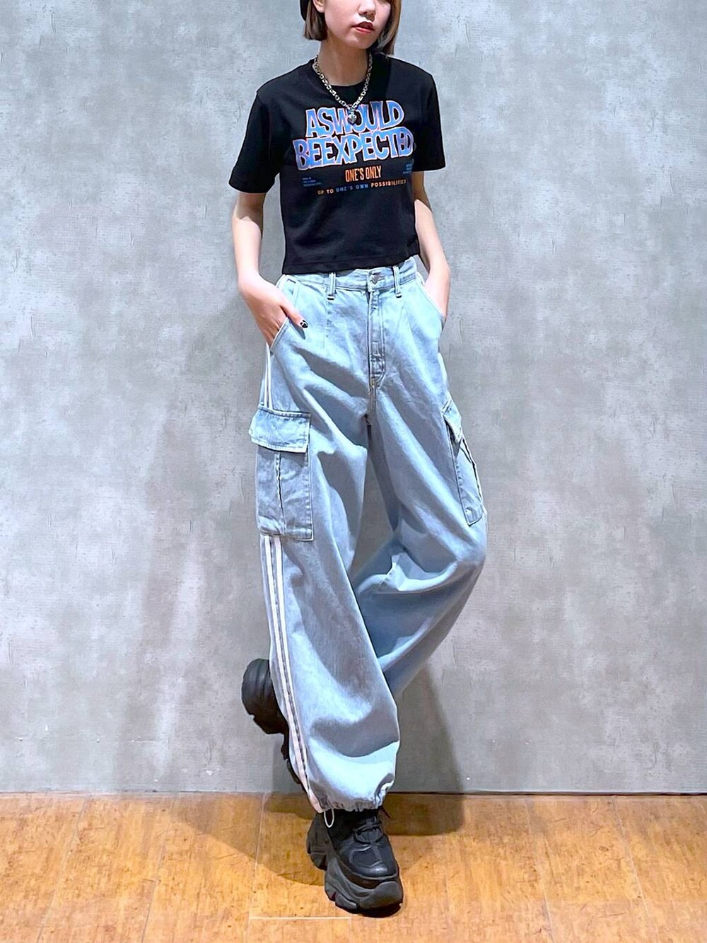 ブラック系のスニーカー、ブルー系のデニムパンツ、ブラック系のTシャツ/カットソーを着用したレディースの夏コーディネートの5枚目の写真
