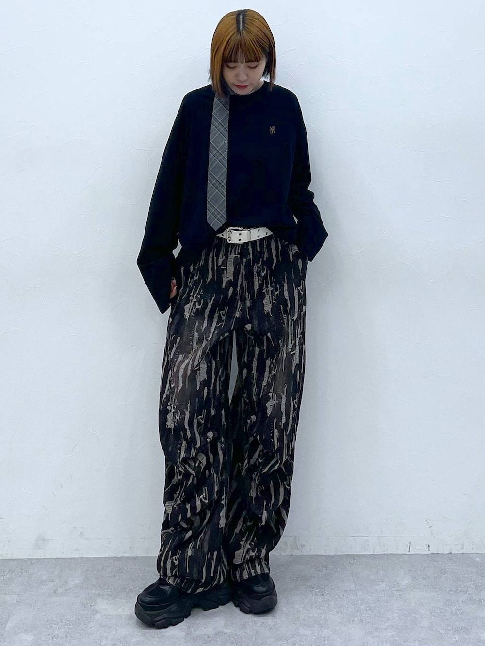 ブラック系のスニーカー、グレー系のネクタイ、ブラック系のデニムパンツを着用したレディースの夏コーディネートの3枚目の写真