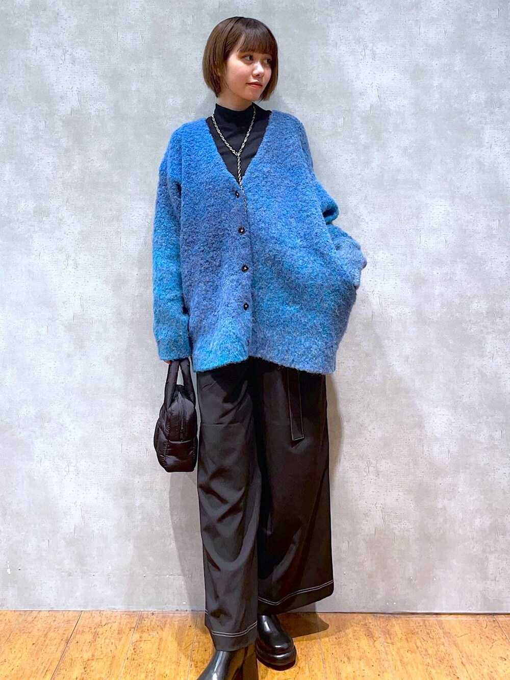 ブラック系のブーツ、ブラック系のその他パンツ、ブラック系のハンドバッグを着用したレディースの秋コーディネートの3枚目の写真