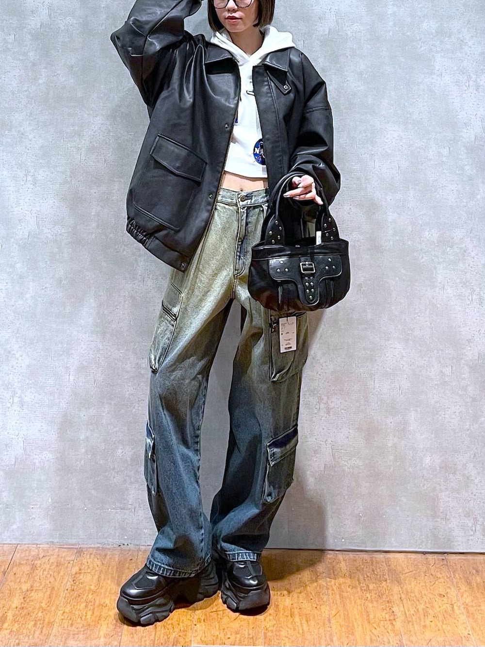 ブラック系のスニーカー、ブラック系のブルゾン、ブルー系のデニムパンツを着用したレディースの秋コーディネートの7枚目の写真