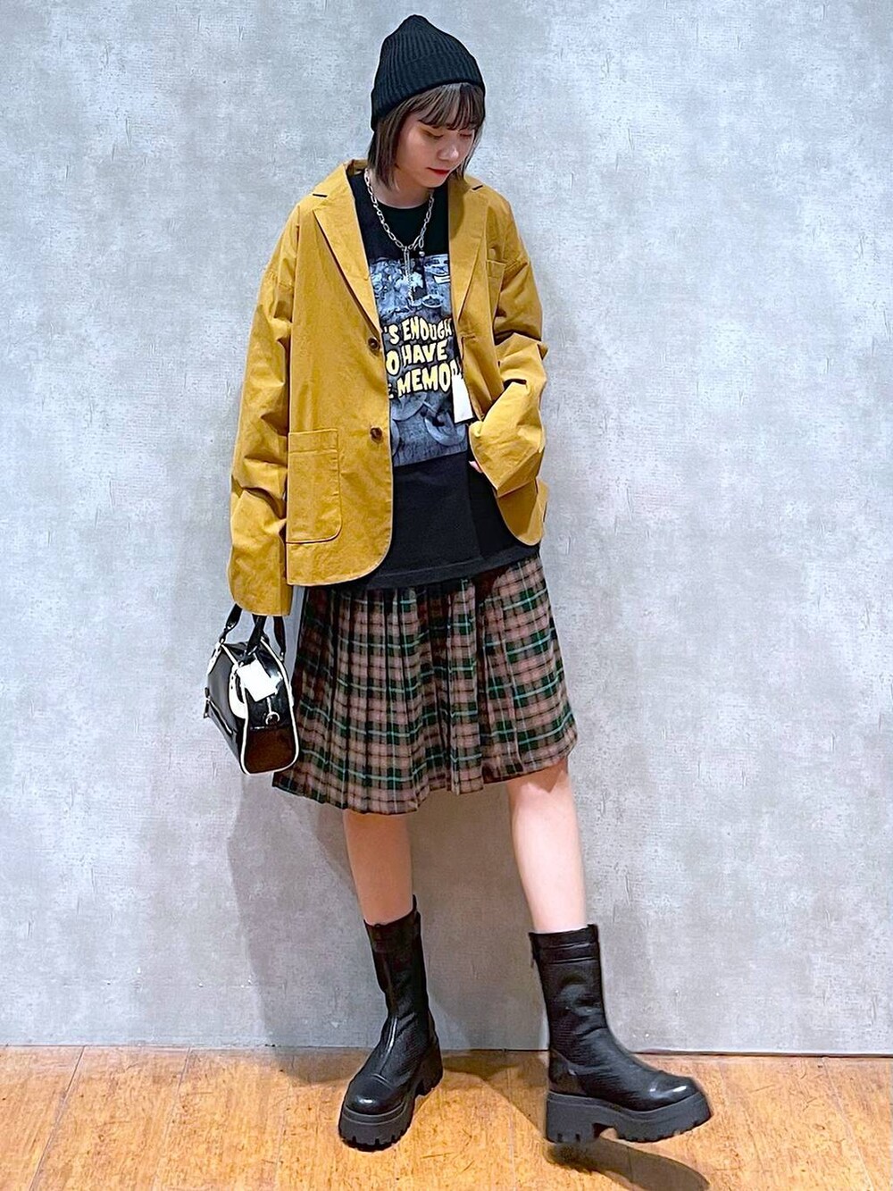 ブラック系のブーツ、ブラック系のショルダーバッグ、ブラック系のTシャツ/カットソーを着用したレディースの秋コーディネートの3枚目の写真