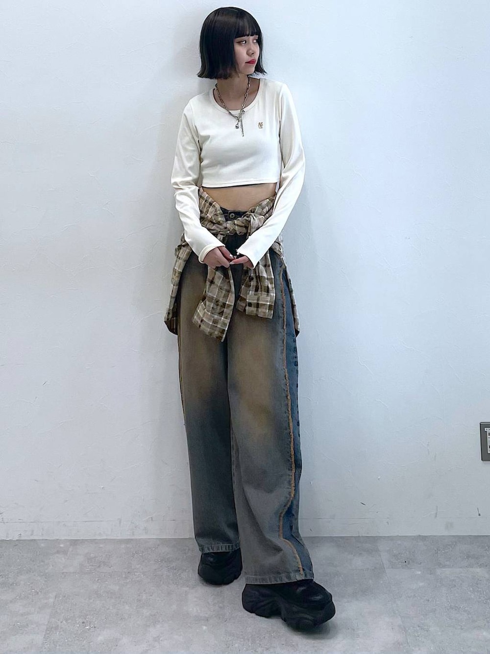 ブラック系のスニーカー、ブラウン系のシャツ/ブラウス、ブルー系のデニムパンツを着用したレディースの夏コーディネートの6枚目の写真