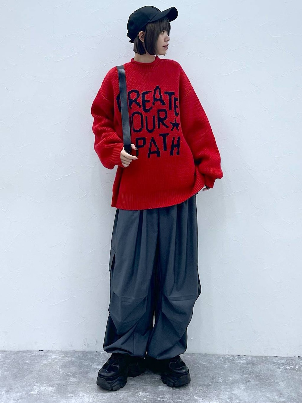 ブラック系のショルダーバッグ、ブラック系のスニーカー、グレー系のカーゴパンツを着用したレディースの秋コーディネートの4枚目の写真