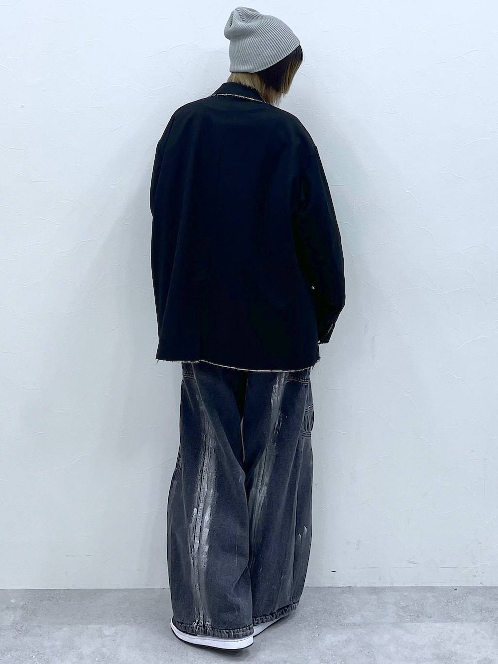 ブラック系のテーラードジャケット、ブラック系のデニムパンツ、ブラック系のスウェットを着用したレディースの冬コーディネートの6枚目の写真