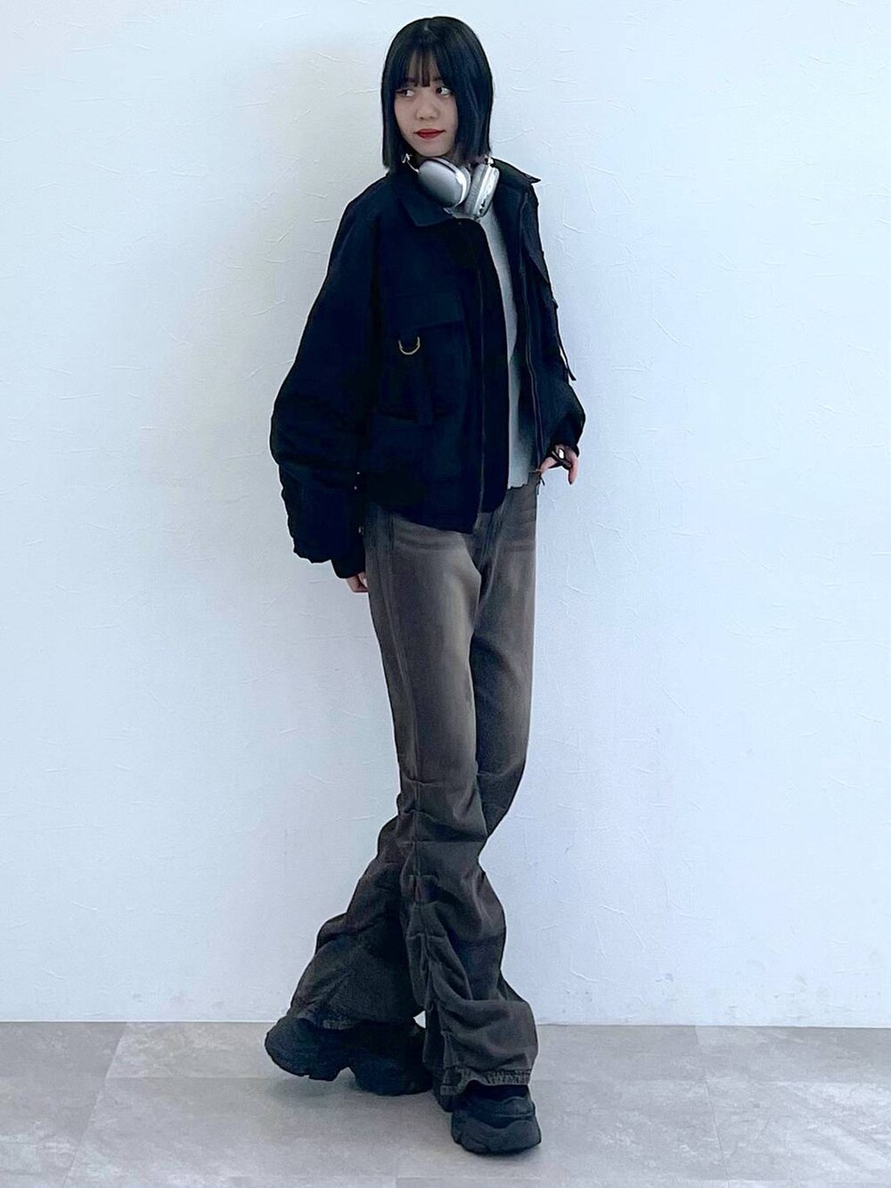 ブラック系のスニーカー、ブラック系のデニムパンツ、グレー系のTシャツ/カットソーを着用したレディースの秋コーディネートの2枚目の写真