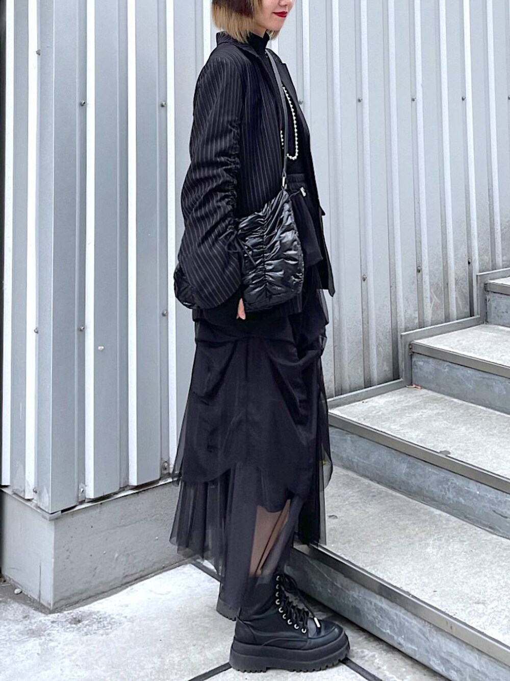 その他のテーラードジャケット、ブラック系のショルダーバッグ、ブラック系のブーツを着用したレディースの冬コーディネートの7枚目の写真