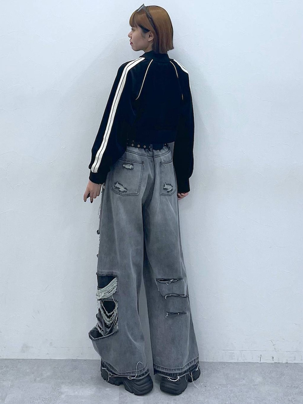 ブラック系のデニムパンツ、ブラック系のスニーカー、ホワイト系のTシャツ/カットソーを着用したレディースの夏コーディネートの7枚目の写真