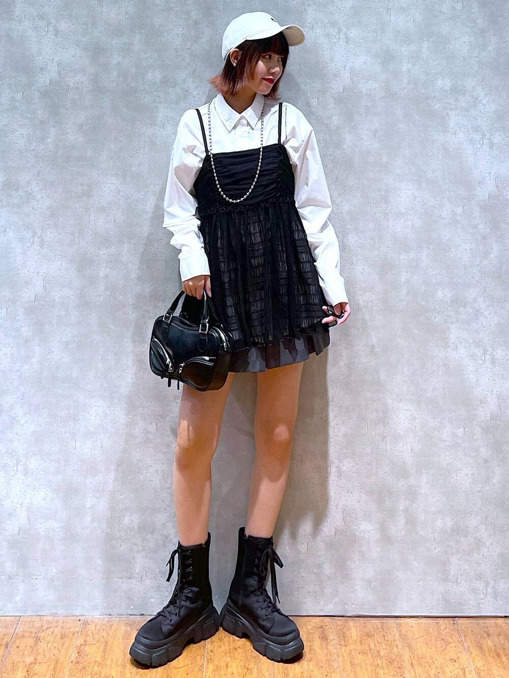 ホワイト系のシャツ/ブラウス、グレー系のその他パンツ、ブラック系のブーツを着用したレディースの春コーディネートの3枚目の写真