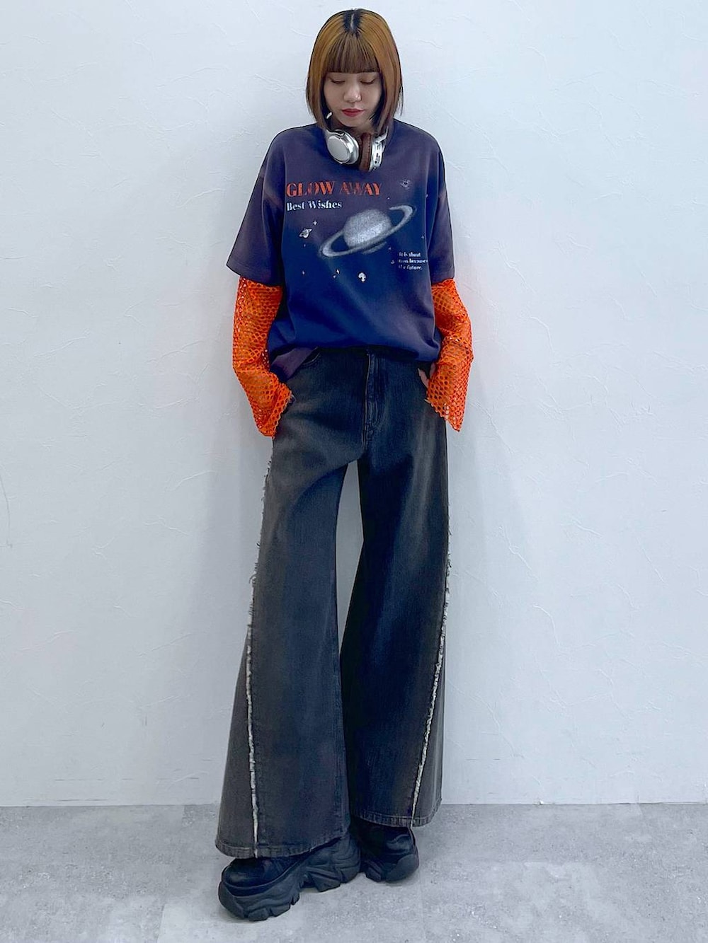 ブラック系のスニーカー、オレンジ系のTシャツ/カットソー、ブラック系のデニムパンツを着用したレディースの夏コーディネートの4枚目の写真