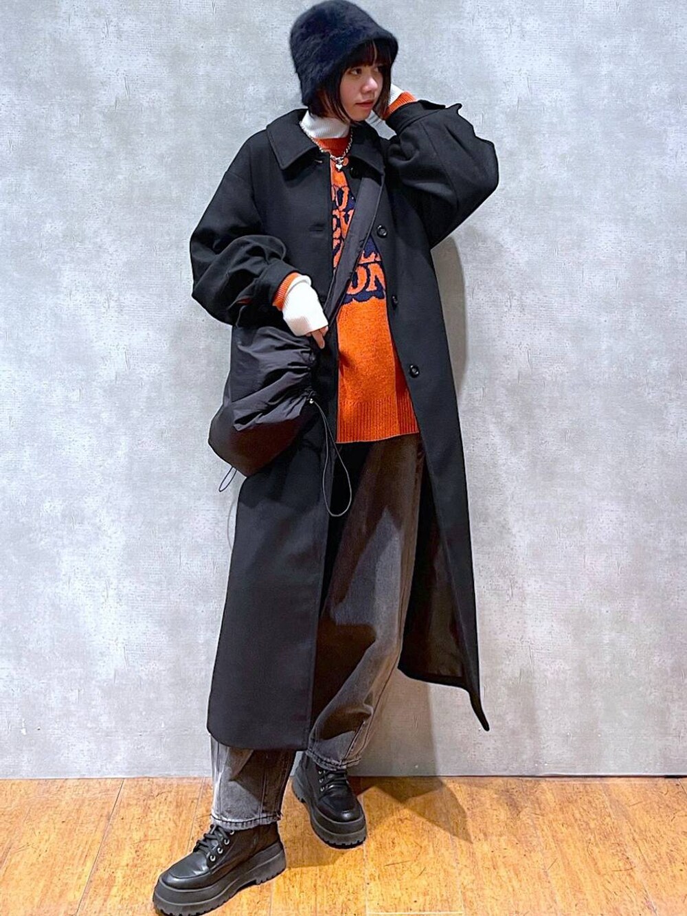 ブラック系のブーツ、ブラック系のチェスターコート、ブラック系のデニムパンツを着用したレディースの冬コーディネートの3枚目の写真