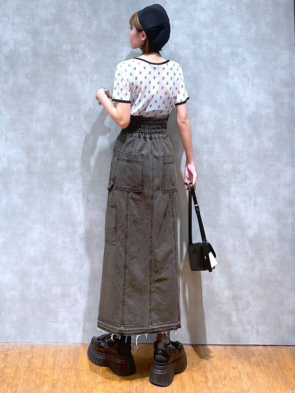 ブラック系のスニーカー、ブラック系のデニムスカート、ブラック系のハンドバッグを着用したレディースの夏コーディネートの6枚目の写真