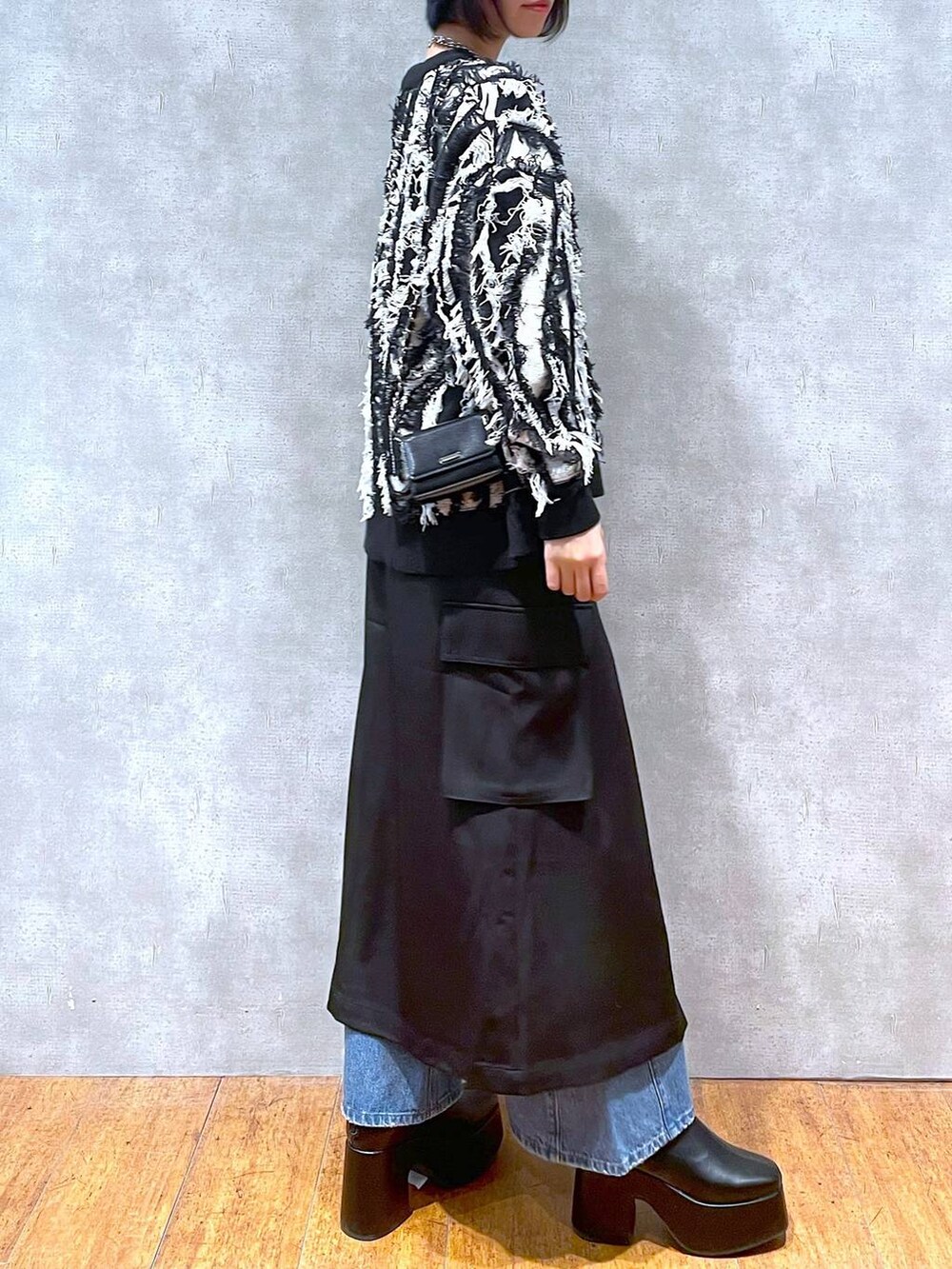 ブラック系のスカート、ブルー系のデニムパンツ、ブラック系のブーツを着用したレディースの冬コーディネートの4枚目の写真