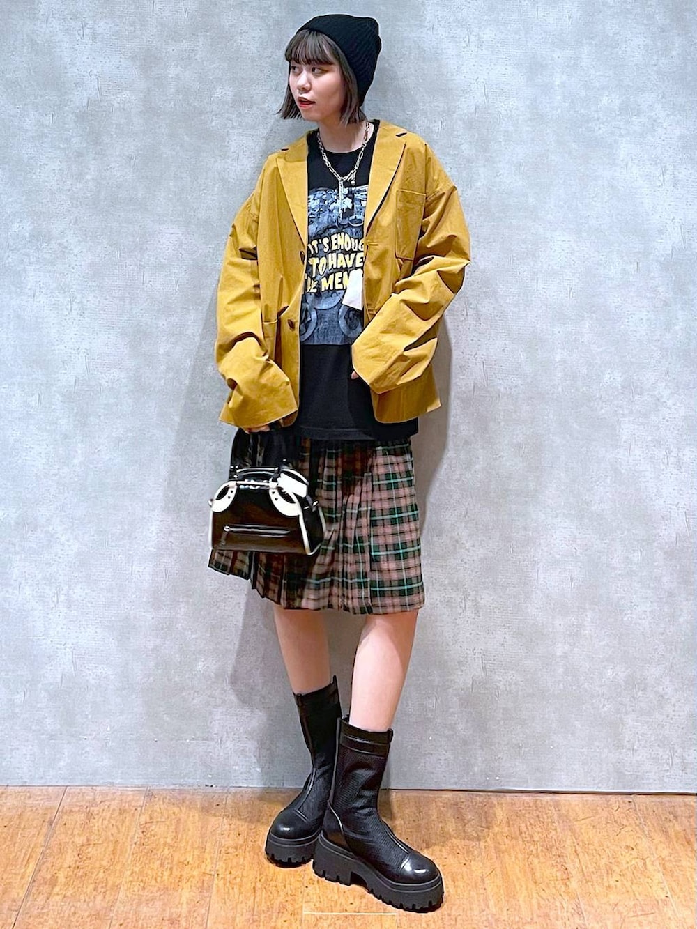 ブラック系のブーツ、ブラック系のショルダーバッグ、ブラック系のTシャツ/カットソーを着用したレディースの秋コーディネートの7枚目の写真