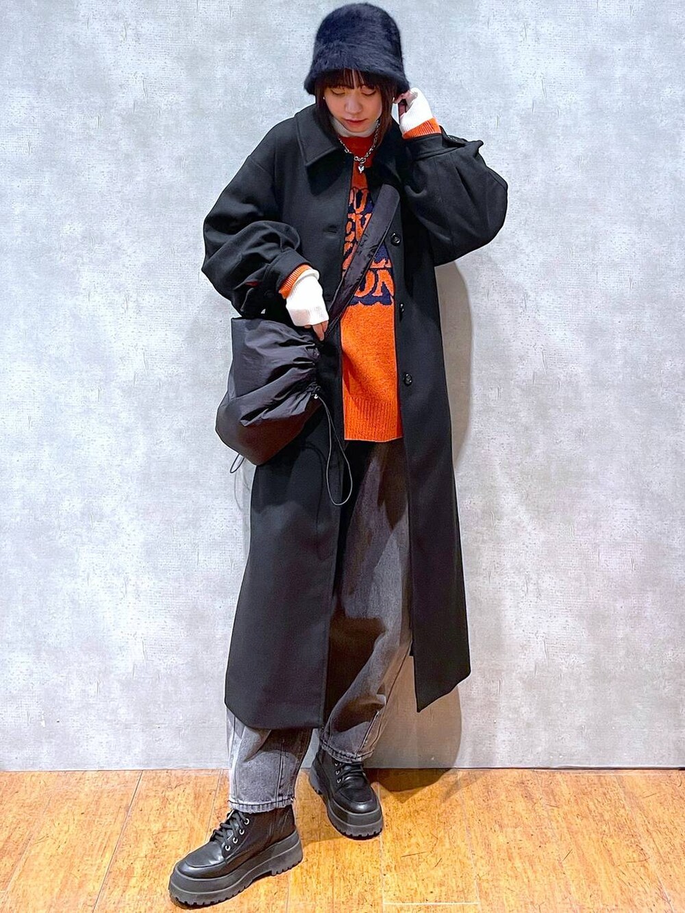 ブラック系のブーツ、ブラック系のチェスターコート、ブラック系のデニムパンツを着用したレディースの冬コーディネートの2枚目の写真