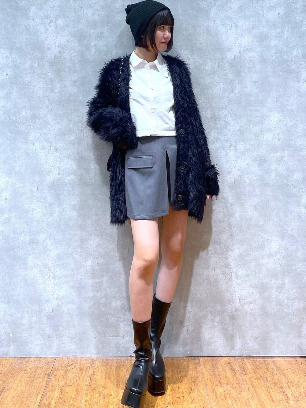 ブラック系のカーディガン/ボレロ、ブラック系のブーツ、ブラック系のショルダーバッグを着用したレディースの冬コーディネートの5枚目の写真