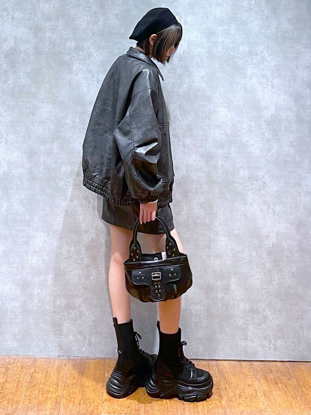 ブラック系のブーツ、ブラック系のブルゾン、ブラウン系のTシャツ/カットソーを着用したレディースの秋コーディネートの4枚目の写真