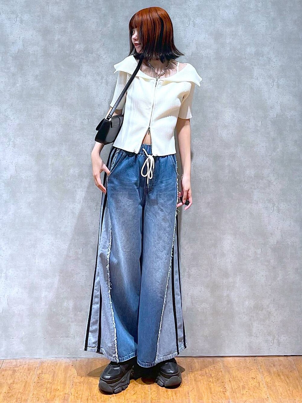 ブラック系のスニーカー、ホワイト系のニット/セーター、ホワイト系のキャミソールを着用したレディースの夏コーディネートの3枚目の写真