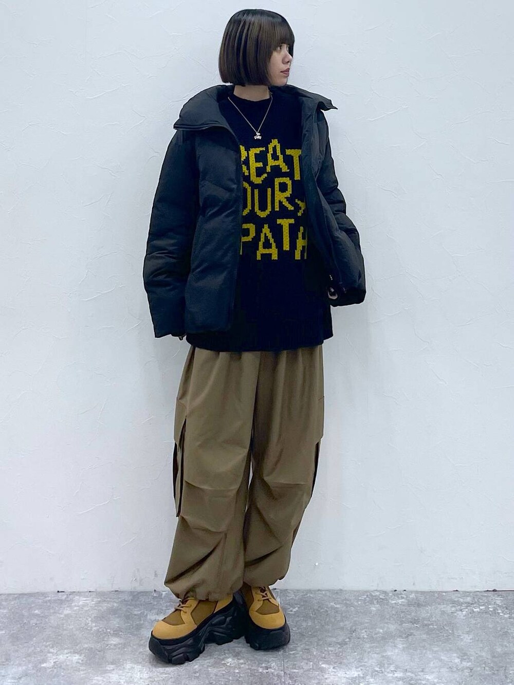 ブラウン系のブーツ、ベージュ系のカーゴパンツ、ブラック系のブルゾンを着用したレディースの秋コーディネートの8枚目の写真