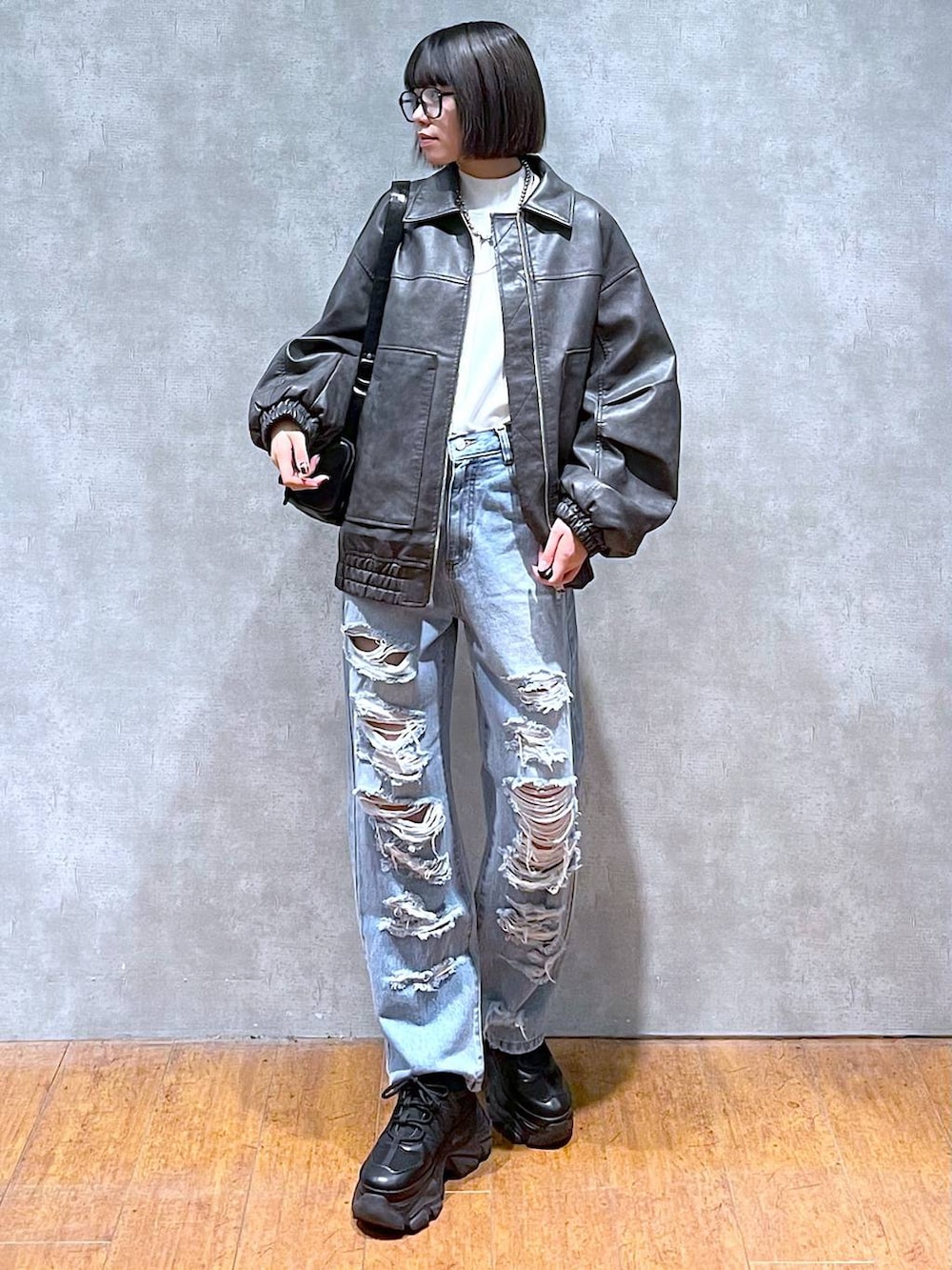 ブラック系のスニーカー、ブルー系のデニムパンツ、グレー系のブルゾンを着用したレディースの秋コーディネートの6枚目の写真