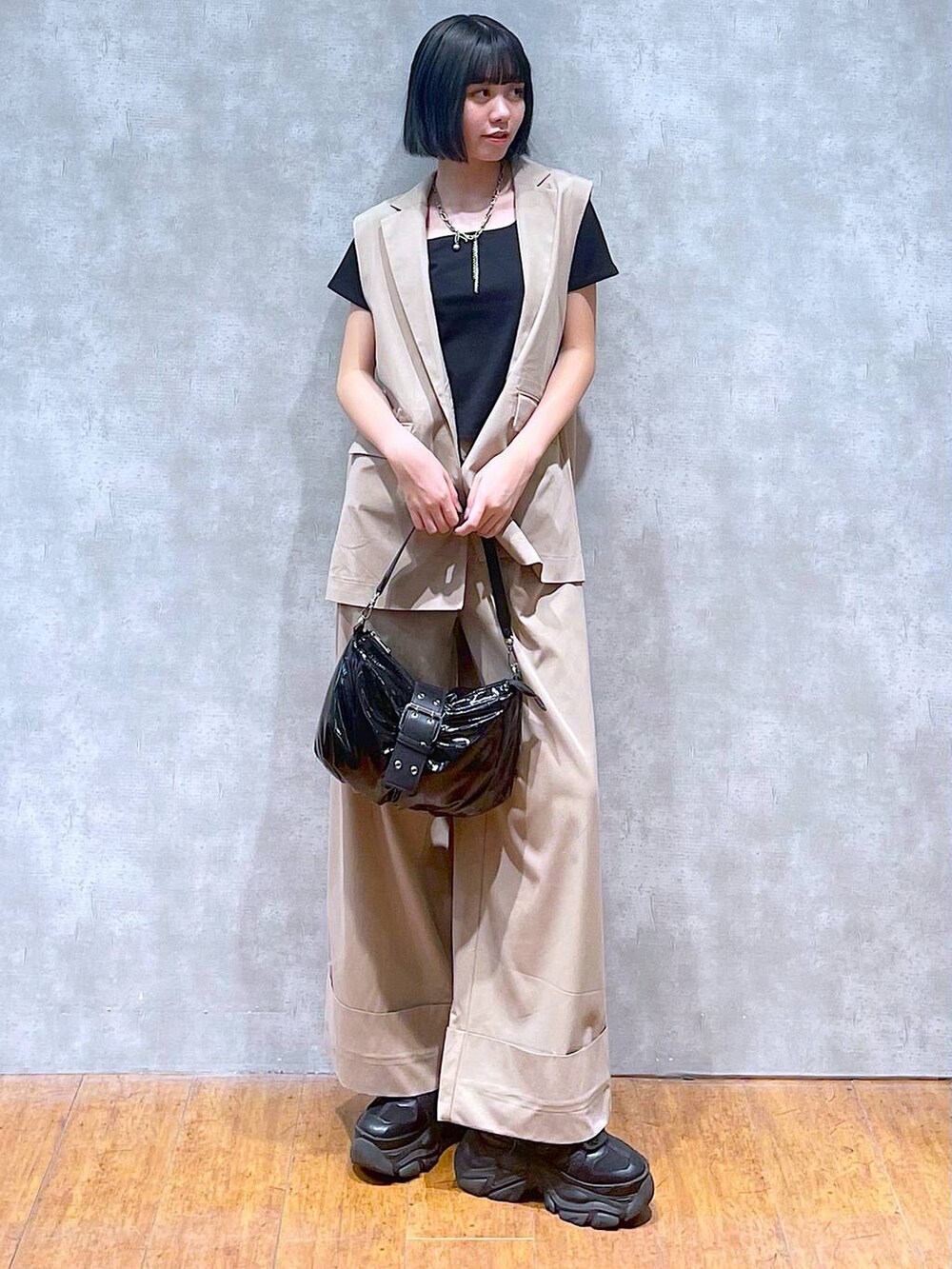 ブラック系のスニーカー、ブラック系のTシャツ/カットソー、ブラック系のショルダーバッグを着用したレディースの夏コーディネートの6枚目の写真