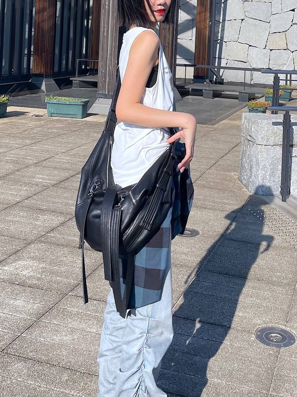 ホワイト系のTシャツ/カットソー、ブルー系のデニムパンツ、ブラウン系のブーツを着用したレディースの秋コーディネートの5枚目の写真