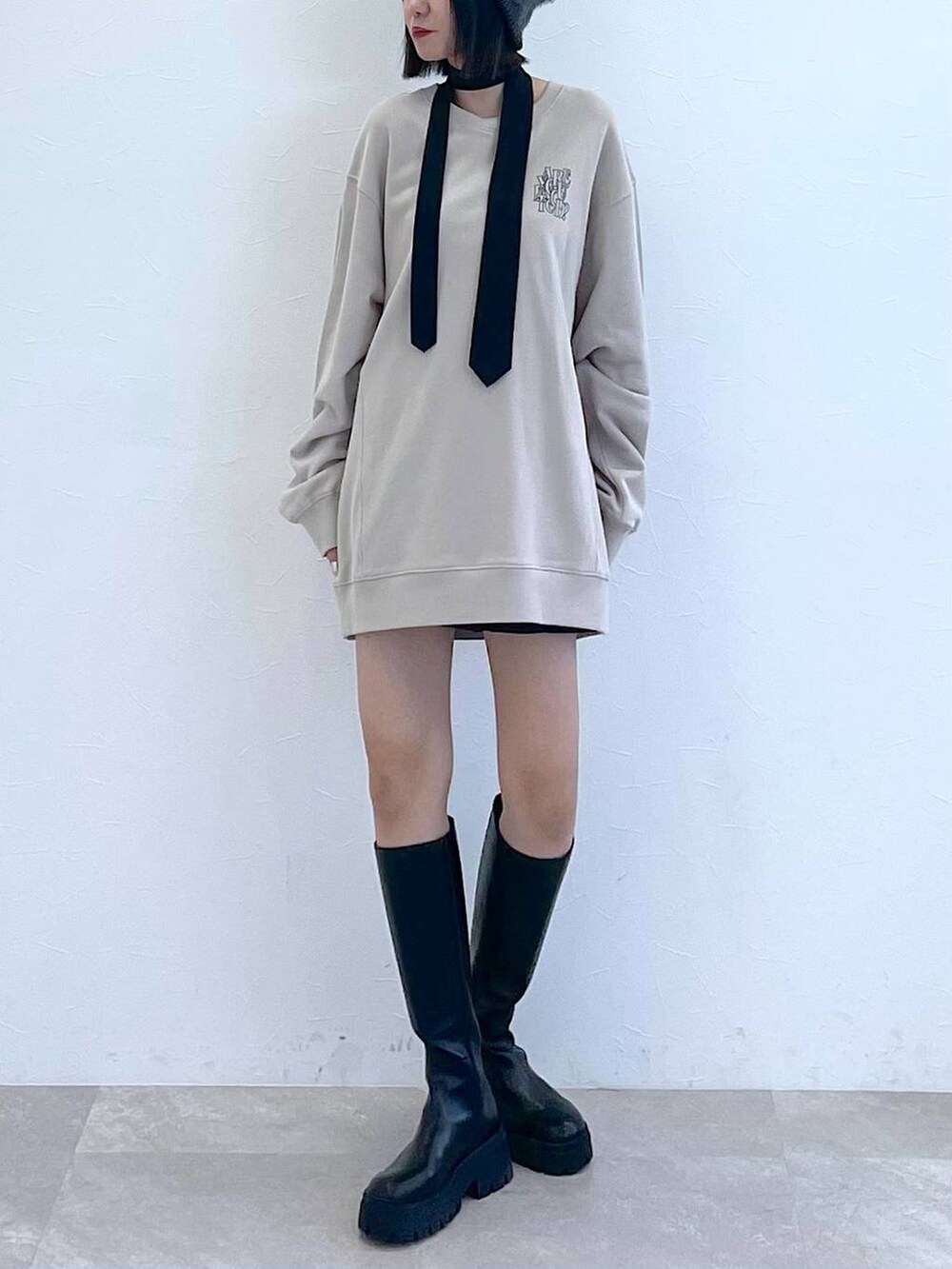 ブラック系のネクタイ、ブラック系のブーツ、ブラック系のその他パンツを着用したレディースの秋コーディネートの9枚目の写真