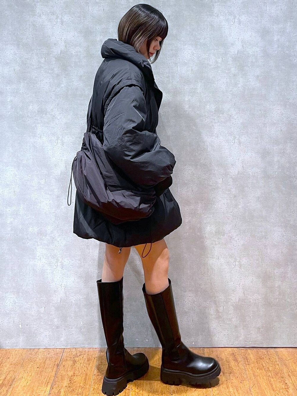 ブラック系のブルゾン、ブルー系のカーディガン/ボレロ、ブラック系のTシャツ/カットソーを着用したレディースの冬コーディネートの2枚目の写真