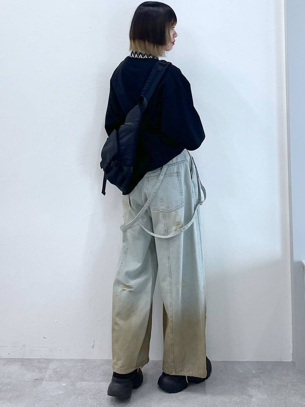 ブラック系のTシャツ/カットソー、ブラック系のボディバッグ/ウエストポーチ、ブラック系のブーツを着用したレディースの春コーディネートの4枚目の写真