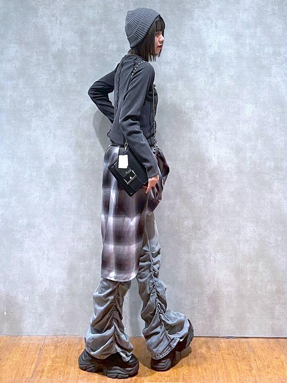 ブラック系のスニーカー、ブルー系のデニムパンツ、グレー系のシャツ/ブラウスを着用したレディースの秋コーディネートの4枚目の写真