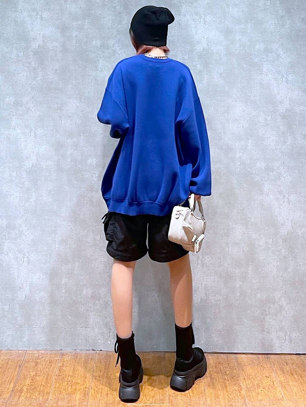 ブラック系のカーゴパンツ、ブルー系のニット/セーター、ベージュ系のボストンバッグを着用したレディースの冬コーディネートの6枚目の写真