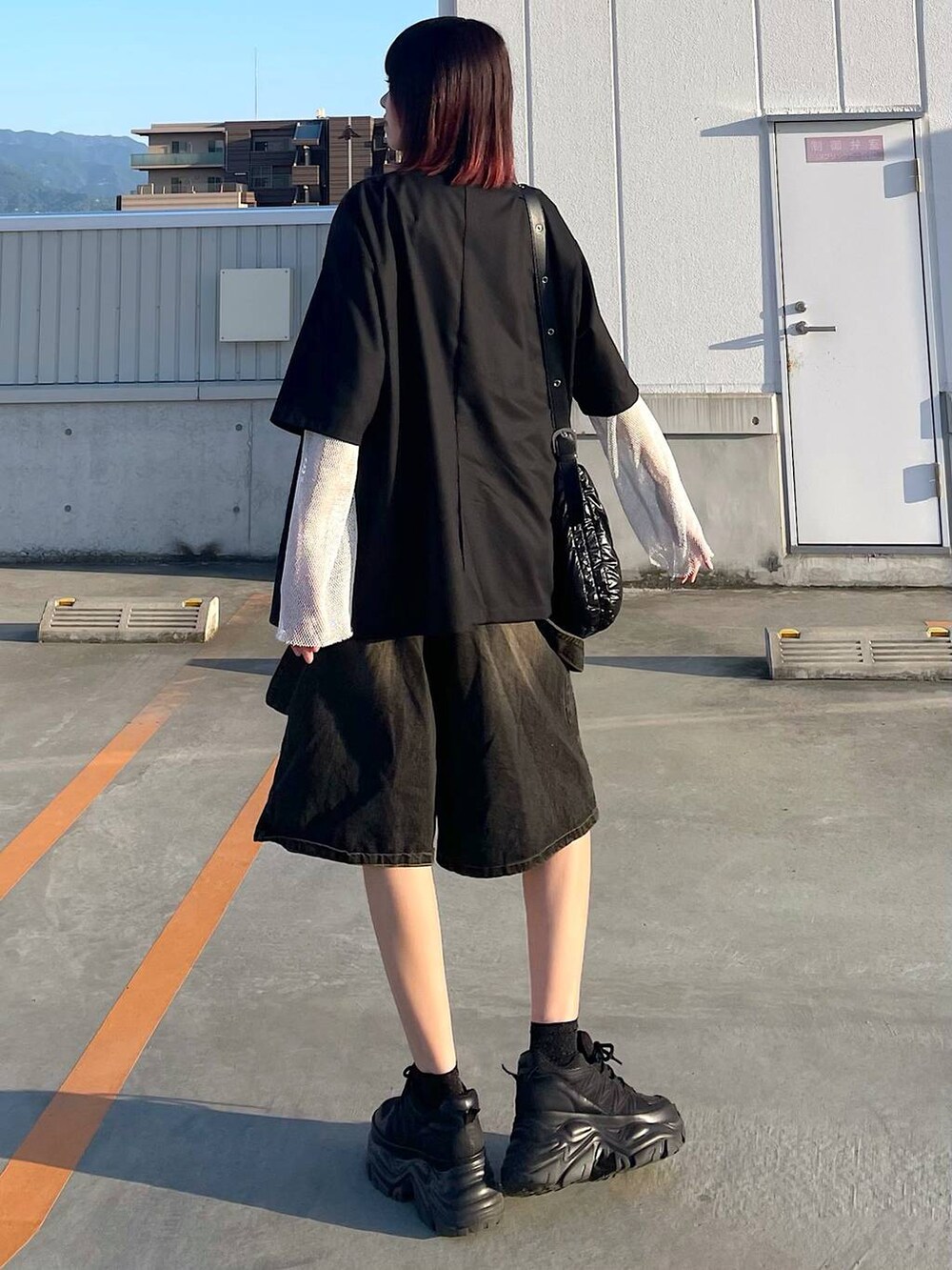 ブラック系のショルダーバッグ、ブラック系のスニーカー、ホワイト系のTシャツ/カットソーを着用したレディースの春コーディネートの5枚目の写真