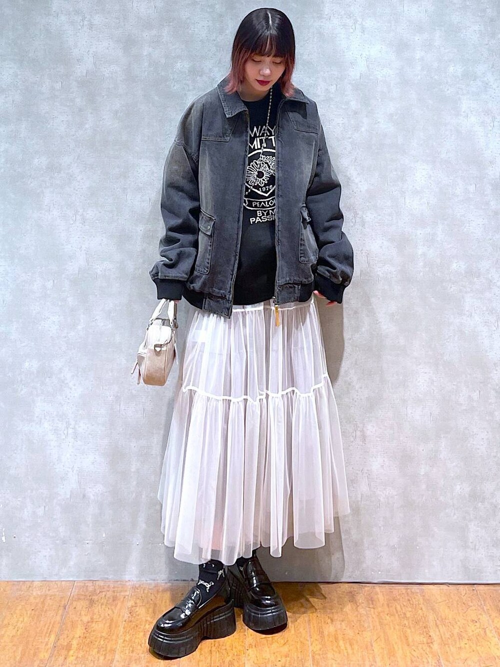 ブラック系のニット/セーター、ブラック系のデニムジャケット、ホワイト系のスカートを着用したレディースの冬コーディネートの3枚目の写真