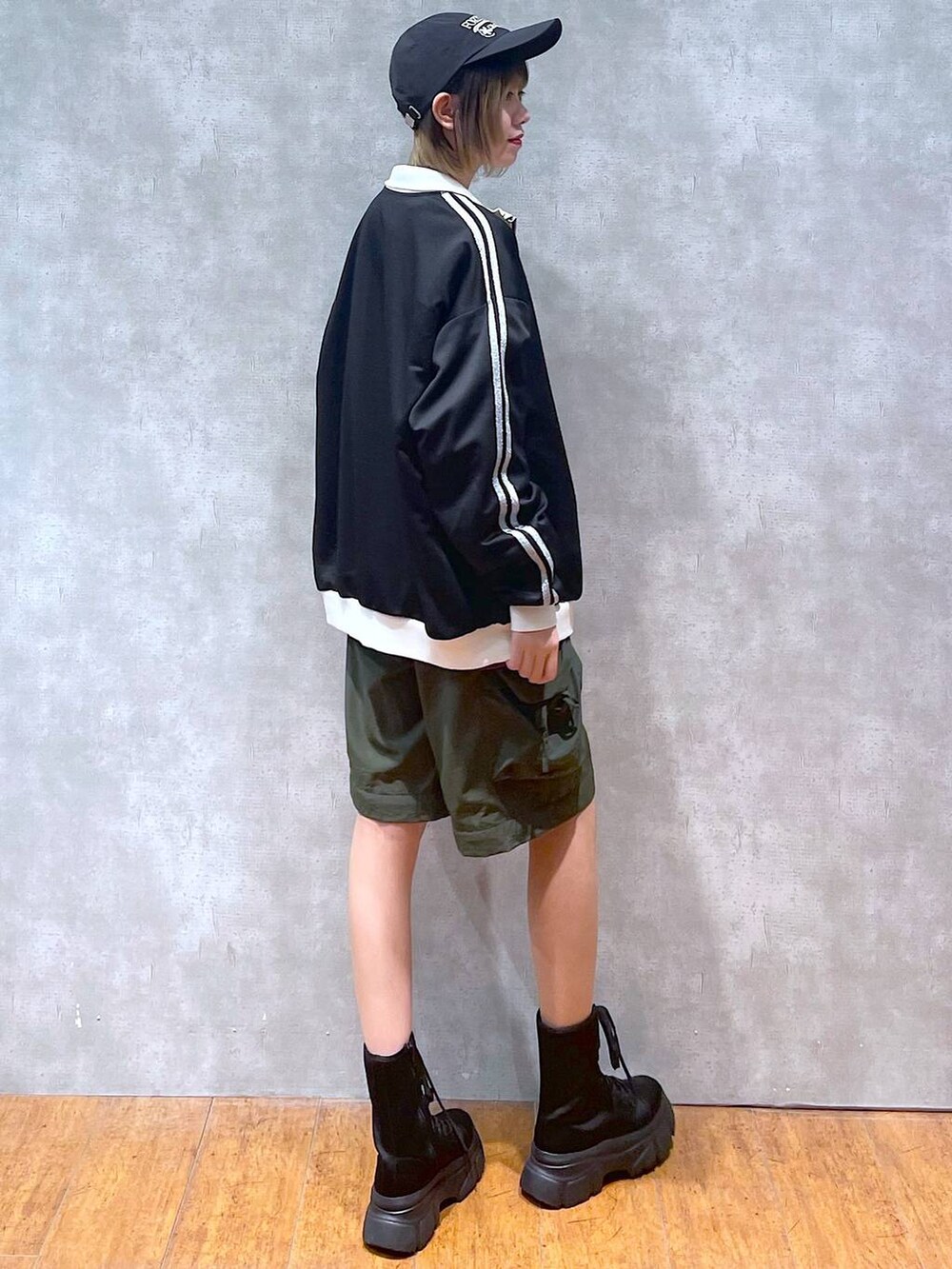 ブラック系のその他アウター、グリーン系のカーゴパンツ、ブラック系のブーツを着用したレディースの冬コーディネートの6枚目の写真