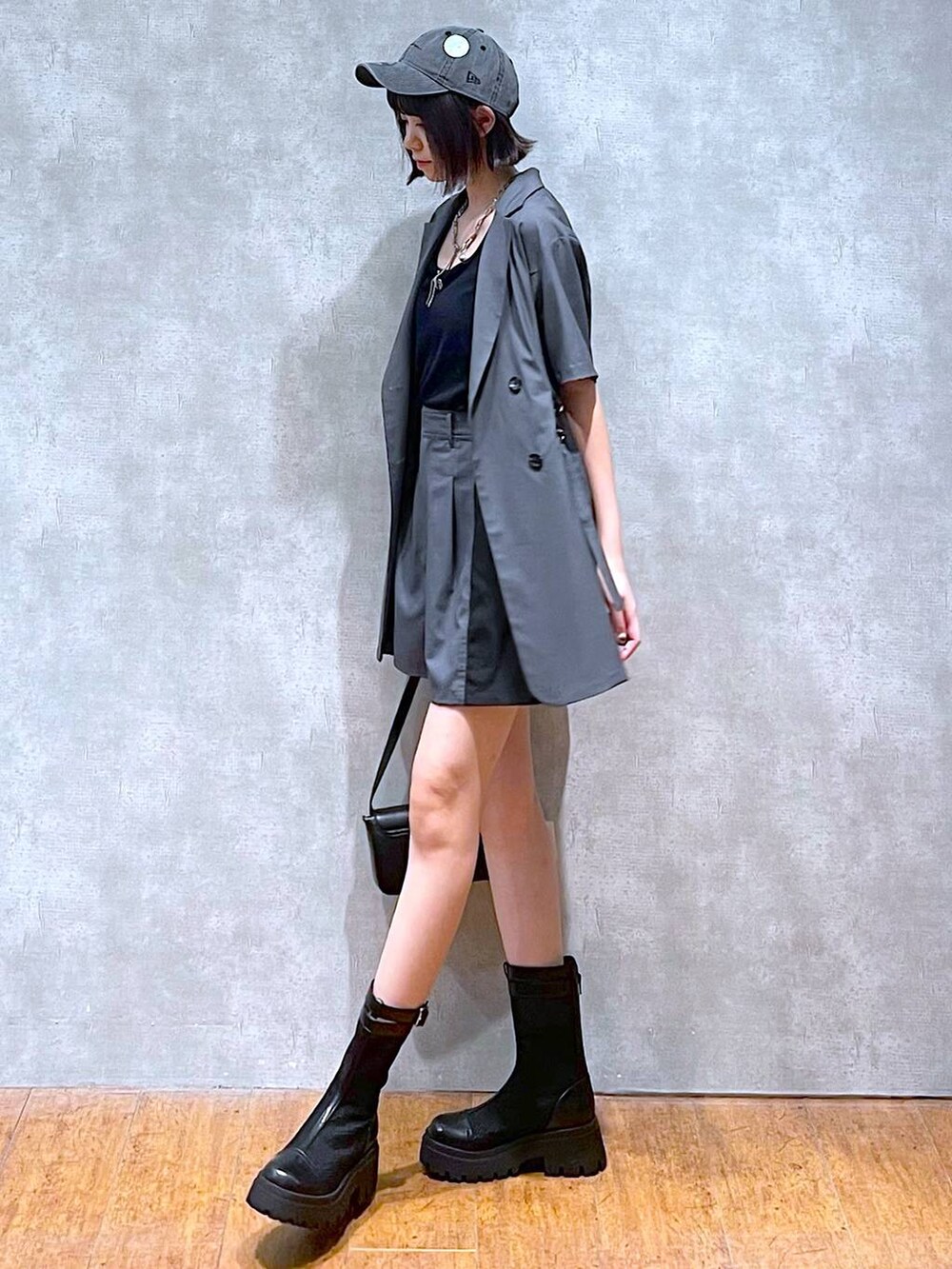 ブラック系のハンドバッグ、グレー系のテーラードジャケット、グレー系のその他パンツを着用したレディースの夏コーディネートの4枚目の写真