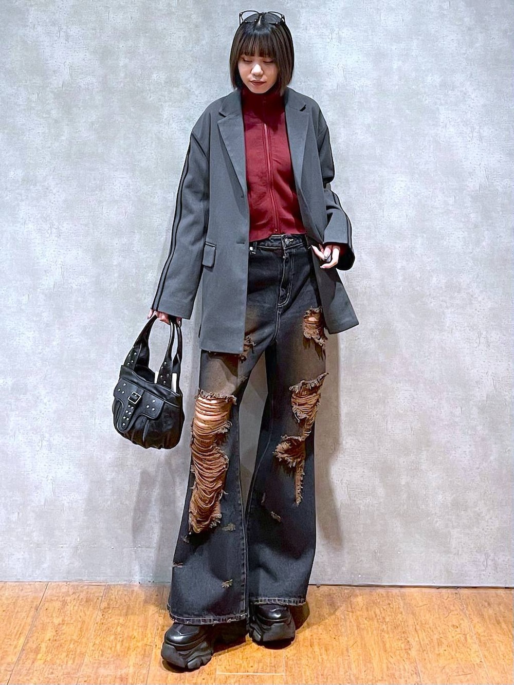 ブラック系のスニーカー、レッド系のニット/セーター、ブラック系のハンドバッグを着用したレディースの秋コーディネートの10枚目の写真