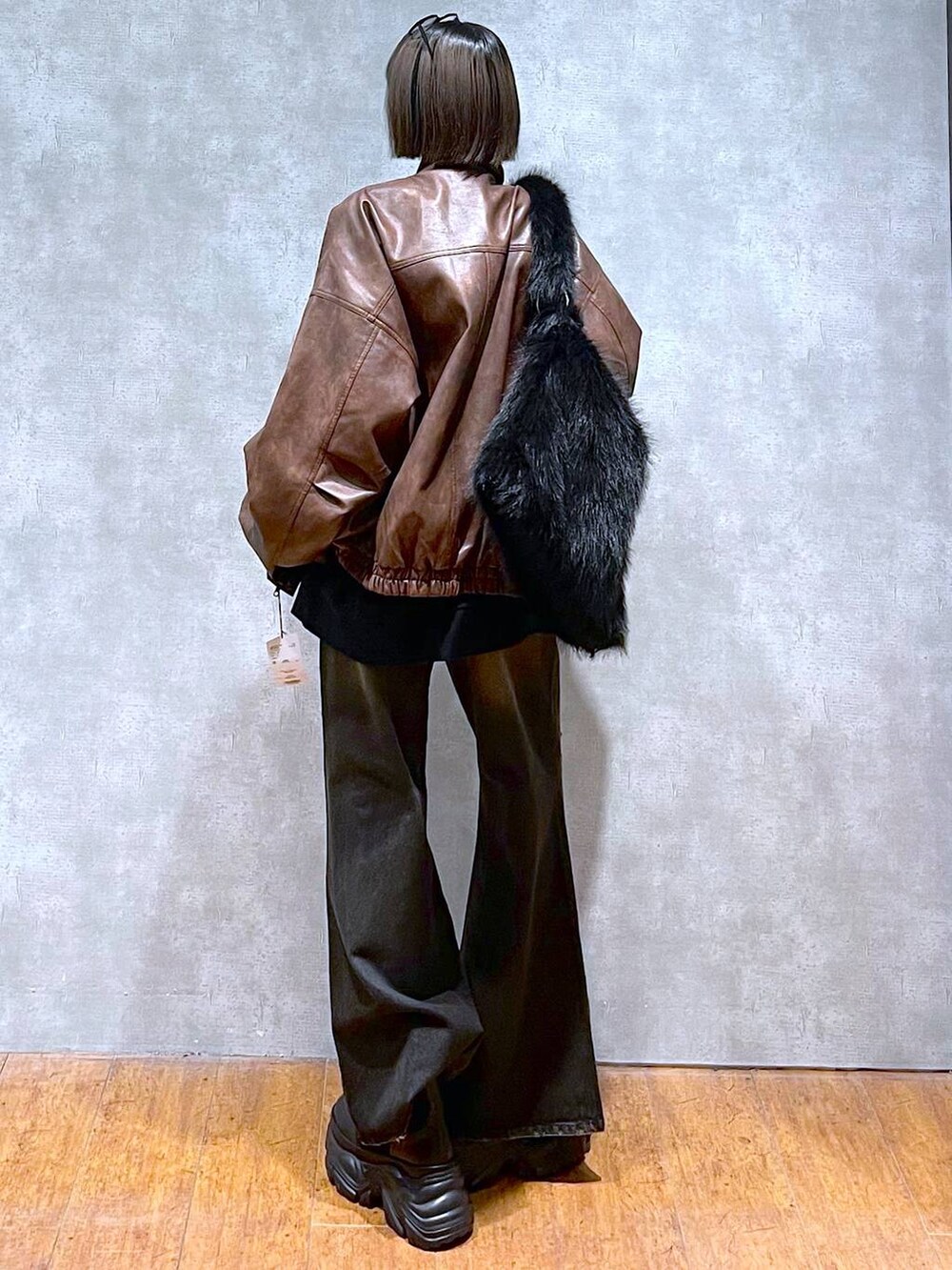 ブラウン系のブルゾン、ブラック系のブーツ、グレー系のスウェットを着用したレディースの秋コーディネートの4枚目の写真