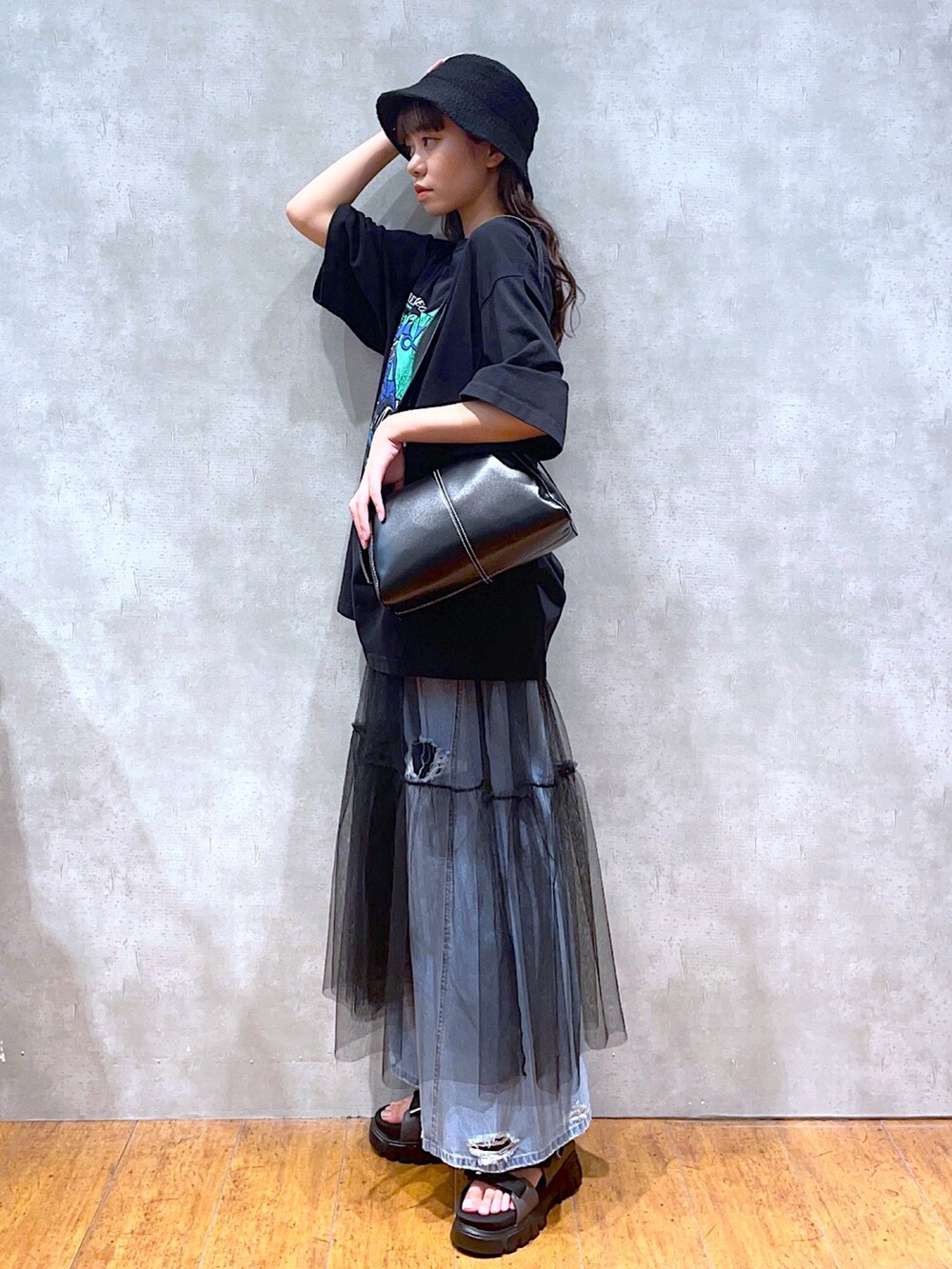 ブラック系のTシャツ/カットソー、ブラック系のショルダーバッグ、ブルー系のデニムパンツを着用したレディースの夏コーディネートの2枚目の写真