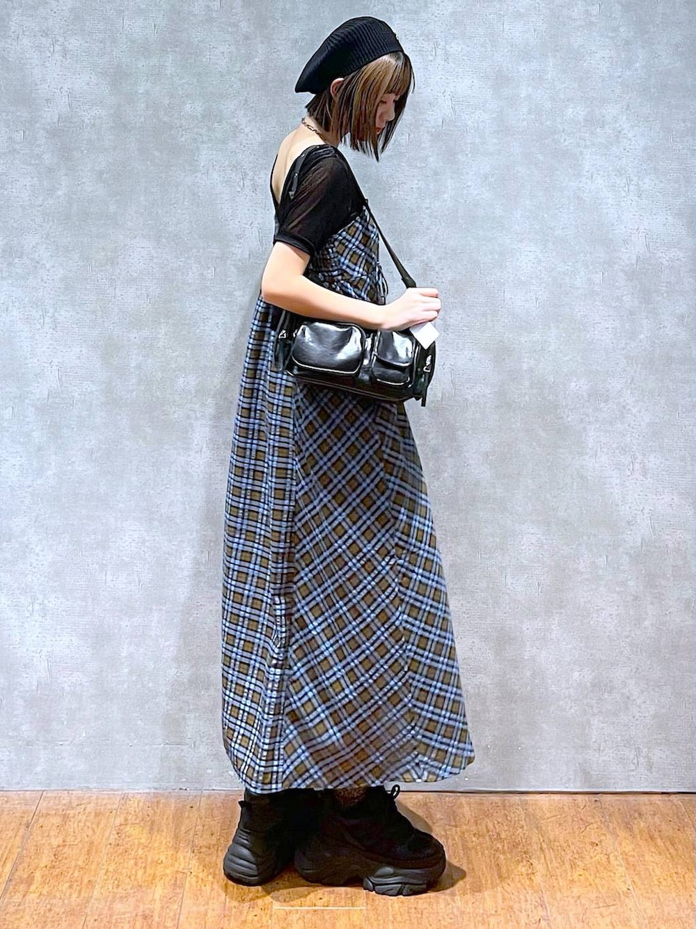 ブラック系のスニーカー、ブラック系のショルダーバッグ、ブルー系のワンピースを着用したレディースの秋コーディネートの4枚目の写真