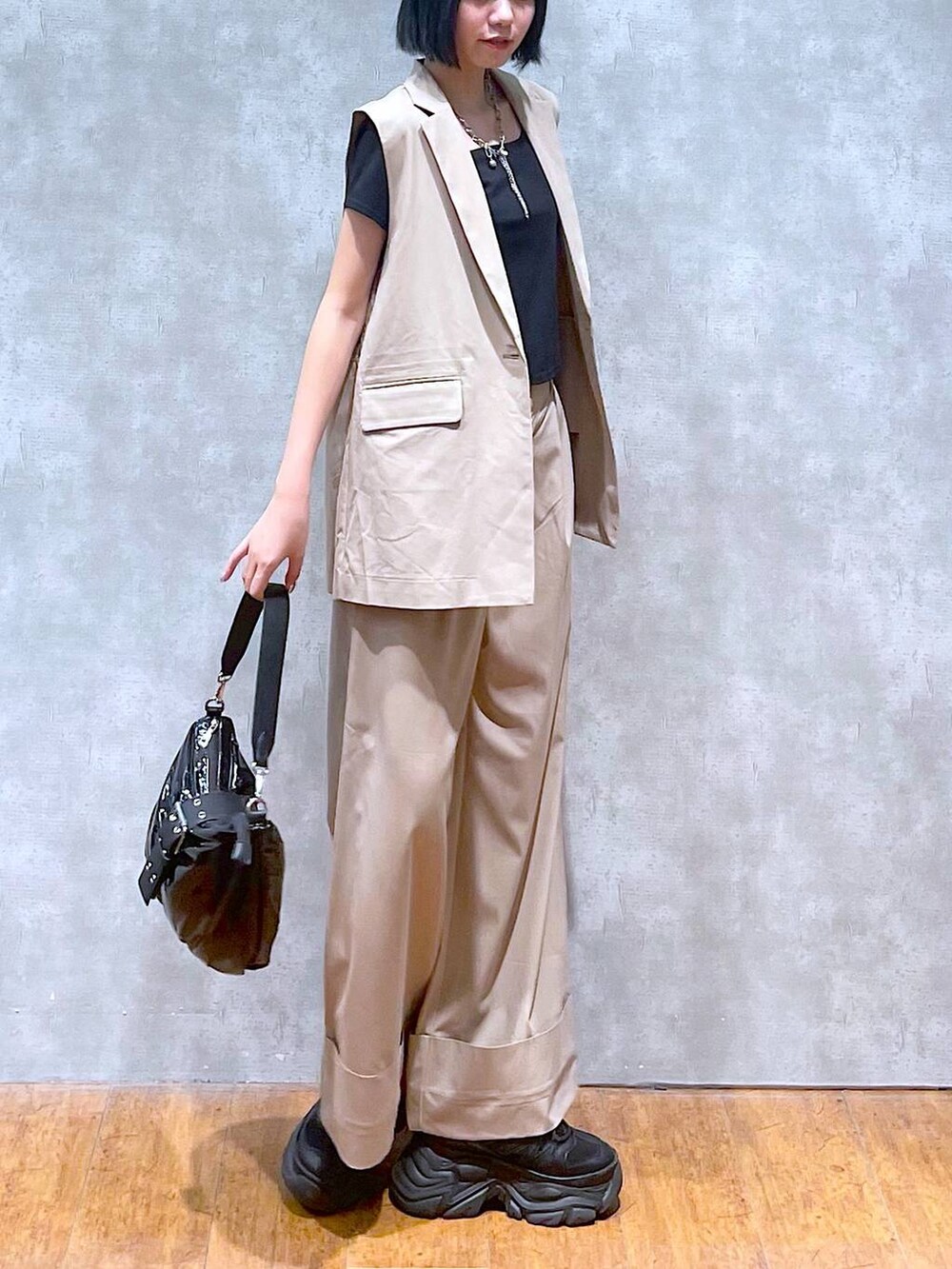 ブラック系のスニーカー、ブラック系のTシャツ/カットソー、ブラック系のショルダーバッグを着用したレディースの夏コーディネートの3枚目の写真