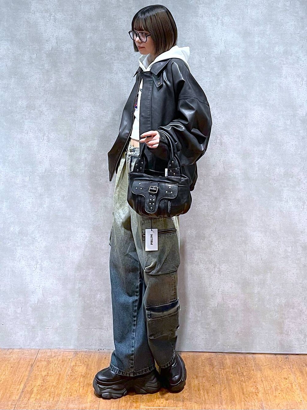 ブラック系のスニーカー、ブラック系のブルゾン、ブルー系のデニムパンツを着用したレディースの秋コーディネートの5枚目の写真