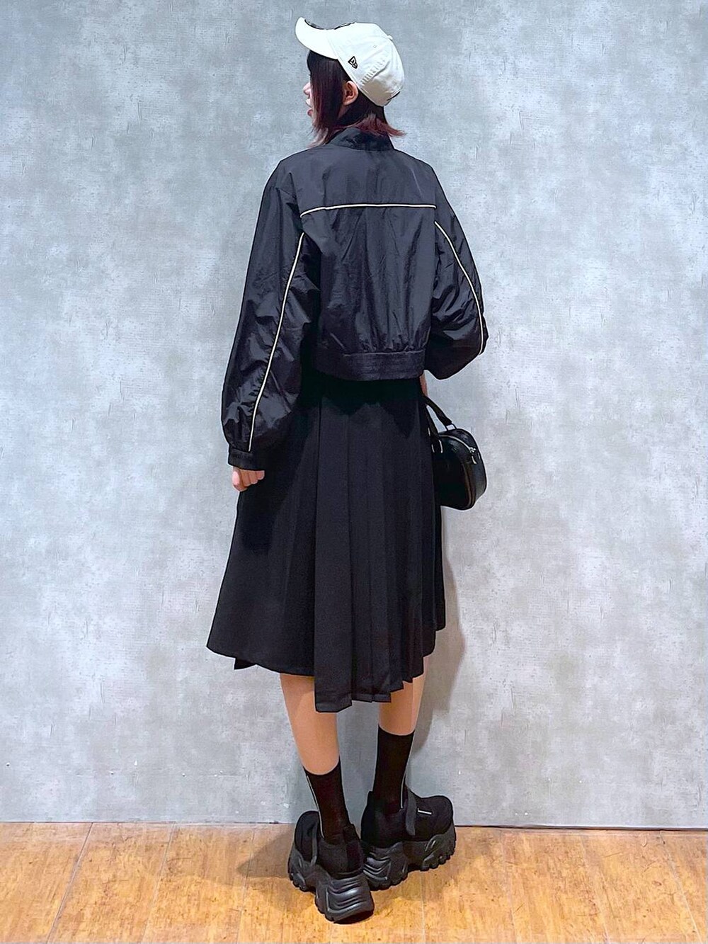 ブラック系のブルゾン、ブラック系のスカート、ブラック系のキャミソールを着用したレディースの春コーディネートの5枚目の写真
