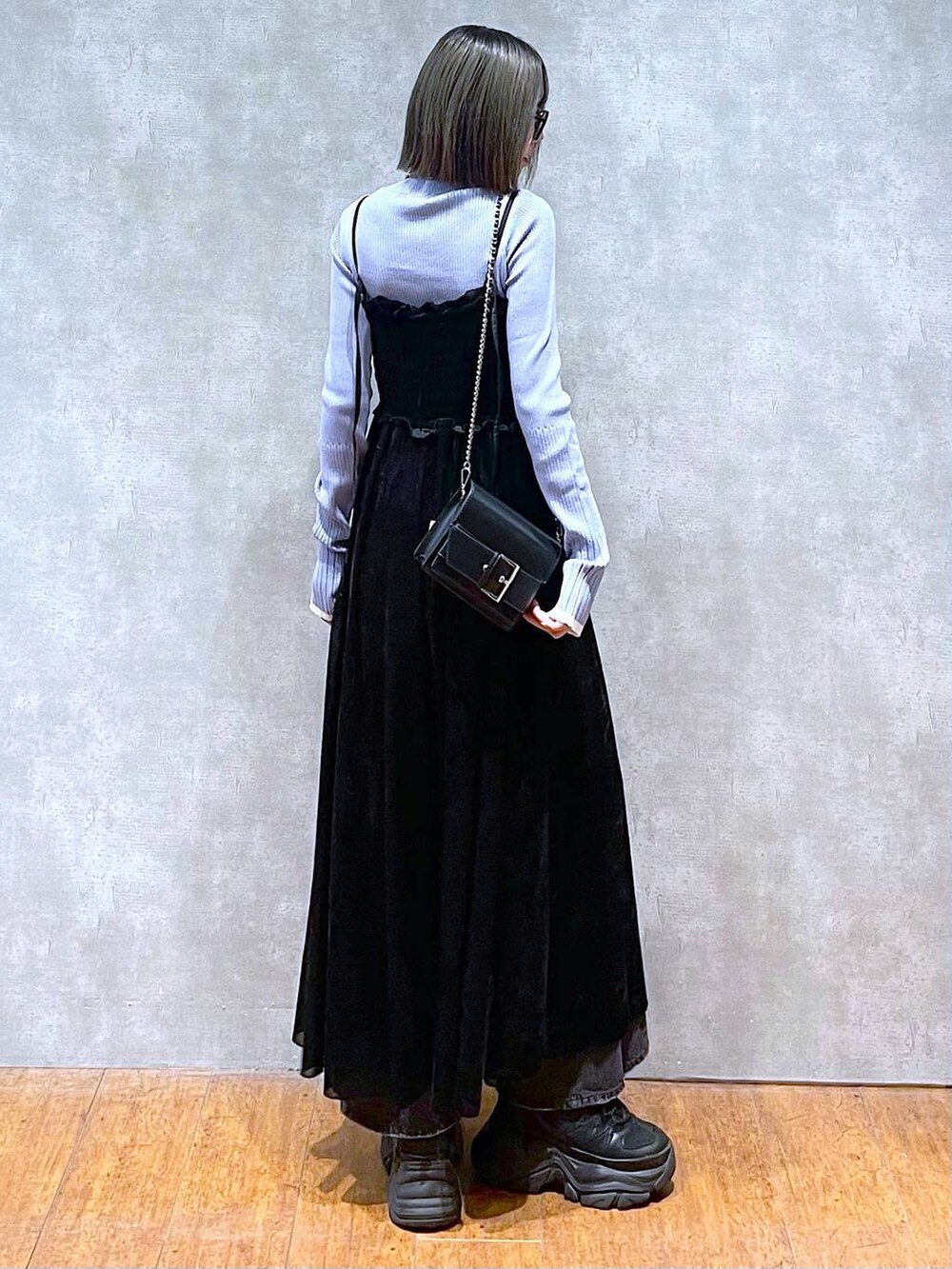 ブラック系のスニーカー、ブルー系のニット/セーター、ブラック系のデニムパンツを着用したレディースの秋コーディネートの4枚目の写真