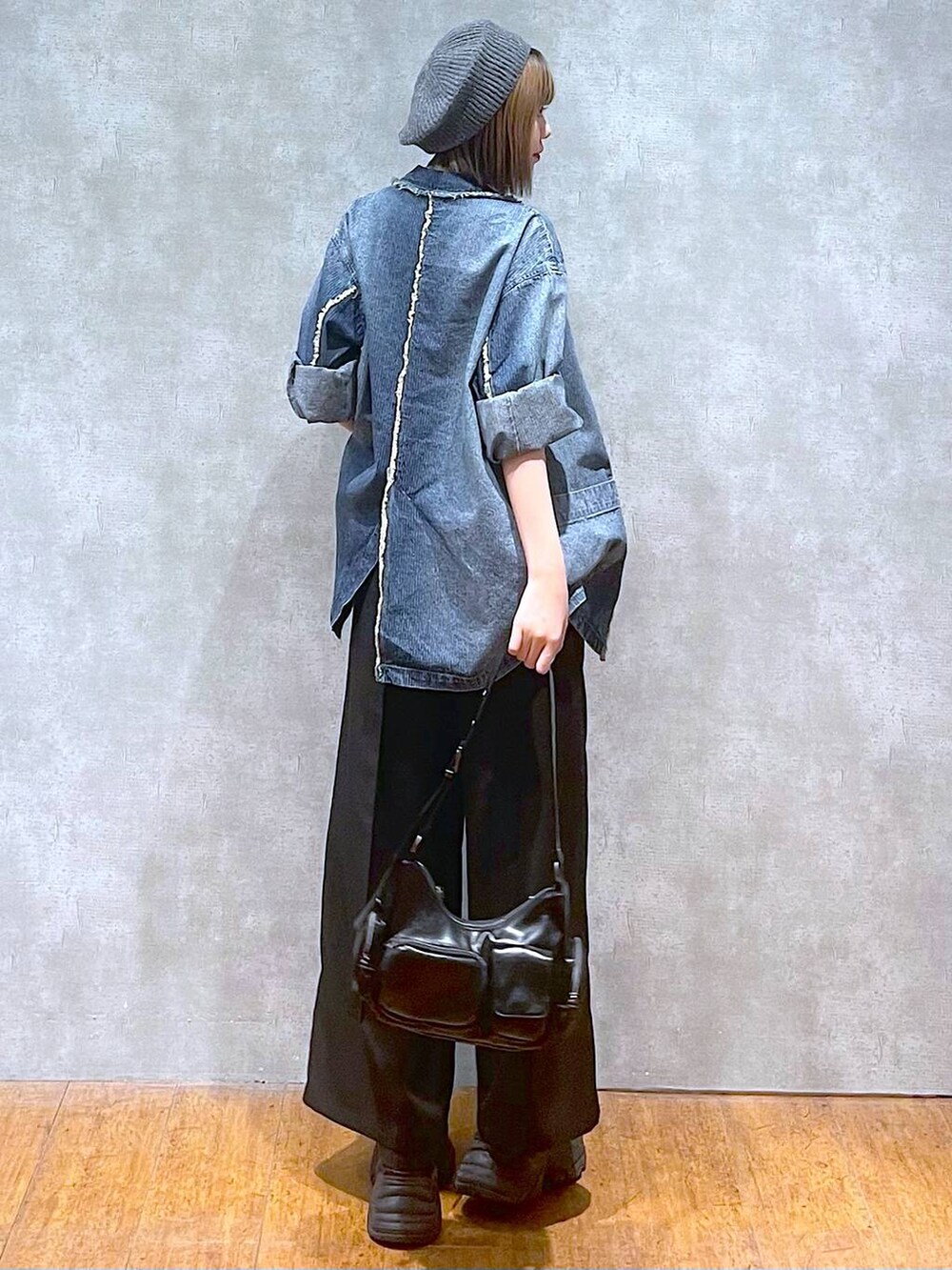 ブラック系のスニーカー、ブルー系のテーラードジャケット、ブラック系のキャミソールを着用したレディースの秋コーディネートの5枚目の写真